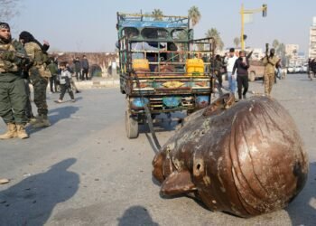 A truck pulls the head of the toppled statue of late Syrian president Hafez al-Assad through the streets of the captured central-west city of Hama on December 6, 2024. - In little over a week, the offensive by rebel forces has seen Syria's second city Aleppo and strategically located Hama fall from President Bashar al-Assad's control for the first time since the civil war began in 2011. (Photo by MUHAMMAD HAJ KADOUR / AFP)