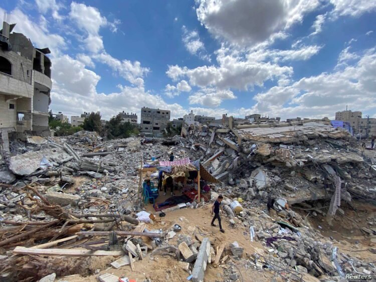 A Palestinian boy from Zawaraa family walks near their makeshift tent amid the rubble of their houses which were destroyed by Israeli air strikes during the Israeli-Palestinian fighting in Gaza May 23, 2021. Picture taken May 23, 2021. REUTERS/Mohammed Salem