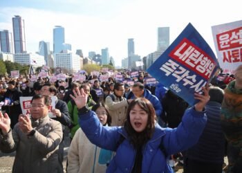 People hold placards that read "Step down President Yoon Suk Yeol" and "Investigate his act of rebellion immediately", at a rally to condemn South Korean President’s surprise declarations of the martial law last night and to call for his resignation, at the national assembly in Seoul, South Korea, December 4, 2024. REUTERS/Kim Hong-Ji