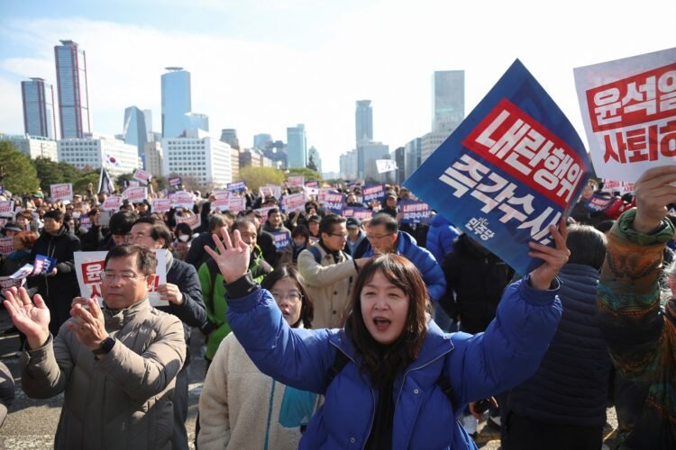 People hold placards that read "Step down President Yoon Suk Yeol" and "Investigate his act of rebellion immediately", at a rally to condemn South Korean President’s surprise declarations of the martial law last night and to call for his resignation, at the national assembly in Seoul, South Korea, December 4, 2024. REUTERS/Kim Hong-Ji