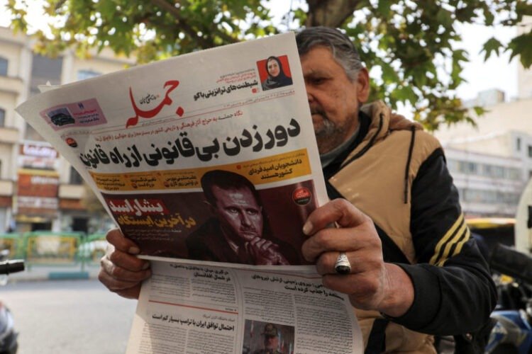 FILE PHOTO: An Iranian man reads a newspaper with a picture of Syrian President Bashar al-Assad in Tehran, Iran December 8, 2024. Majid Asgaripour/WANA (West Asia News Agency) via REUTERS ATTENTION EDITORS - THIS PICTURE WAS PROVIDED BY A THIRD PARTY/File Photo