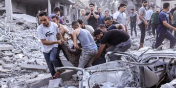 EDITORS NOTE: Graphic content / TOPSHOT - Palestinians evacuate a victim following an Israeli airstrike on Rafah, in the southern Gaza Strip on October 17, 2023, amid the ongoing battles between Israel and the Palestinian group Hamas. Relief convoys which have been waiting for days in Egypt were on October 17, headed towards the Rafah border crossing with the besieged Palestinian enclave of Gaza, aid officials said, as thousands of people, both Israeli and Palestinians have died since October 7, 2023, after Palestinian Hamas militants based in the Gaza Strip, entered southern Israel in a surprise attack leading Israel to declare war on Hamas in Gaza on October 8. (Photo by MOHAMMED ABED / AFP)