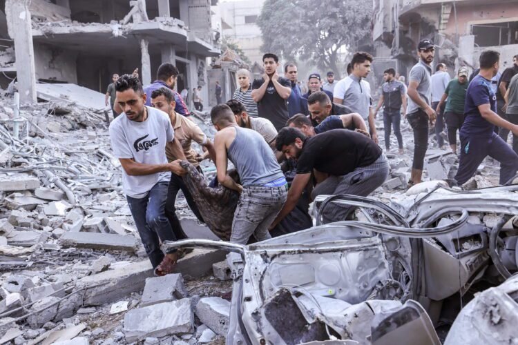 EDITORS NOTE: Graphic content / TOPSHOT - Palestinians evacuate a victim following an Israeli airstrike on Rafah, in the southern Gaza Strip on October 17, 2023, amid the ongoing battles between Israel and the Palestinian group Hamas. Relief convoys which have been waiting for days in Egypt were on October 17, headed towards the Rafah border crossing with the besieged Palestinian enclave of Gaza, aid officials said, as thousands of people, both Israeli and Palestinians have died since October 7, 2023, after Palestinian Hamas militants based in the Gaza Strip, entered southern Israel in a surprise attack leading Israel to declare war on Hamas in Gaza on October 8. (Photo by MOHAMMED ABED / AFP)