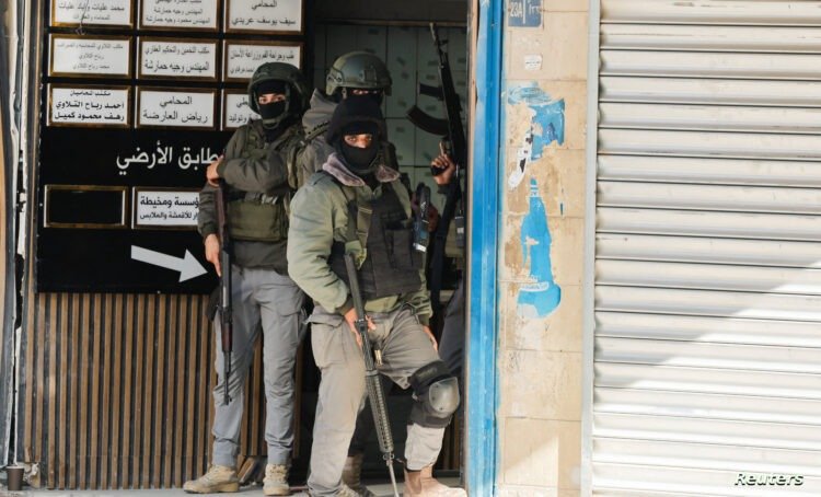 Palestinian security forces take position during clashes with militants at the camp, in Jenin in the Israeli-occupied West Bank, December 14, 2024. REUTERS/Raneen Sawafta