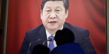 People look at a portrait of Chinese President Xi Jinping at the Museum of the Communist Party of China in Beijing on February 23, 2025, ahead of the opening of the annual session of the National People’s Congress on March. (Photo by Pedro PARDO / AFP)