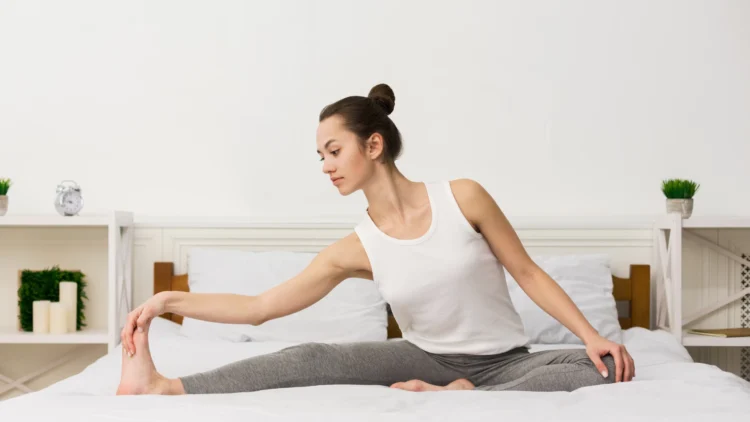 0 Morning stretching routine concept. Girl stretching her legs and doing yoga in her bed. 1