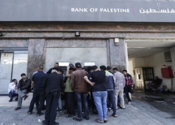 Palestinian employees queue outside a cash machine outside the Bank of Palestine as they wait to withdraw their salaries, in Gaza City on April 9, 2018. / AFP PHOTO / MAHMUD HAMS        (Photo credit should read MAHMUD HAMS/AFP/Getty Images)
