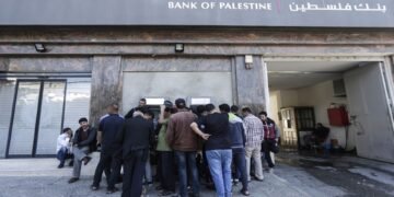 Palestinian employees queue outside a cash machine outside the Bank of Palestine as they wait to withdraw their salaries, in Gaza City on April 9, 2018. / AFP PHOTO / MAHMUD HAMS        (Photo credit should read MAHMUD HAMS/AFP/Getty Images)
