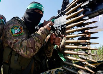 FILE PHOTO: A Palestinian fighter from the armed wing of Hamas takes part in a military parade to mark the anniversary of the 2014 war with Israel, near the border in the central Gaza Strip, July 19, 2023. REUTERS/Ibraheem Abu Mustafa/File Photo