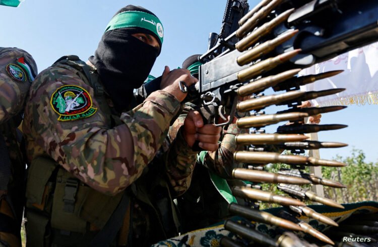 FILE PHOTO: A Palestinian fighter from the armed wing of Hamas takes part in a military parade to mark the anniversary of the 2014 war with Israel, near the border in the central Gaza Strip, July 19, 2023. REUTERS/Ibraheem Abu Mustafa/File Photo