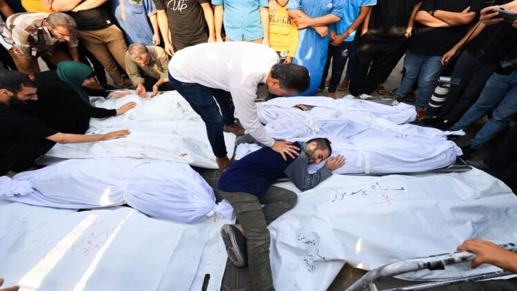 EDITORS NOTE: Graphic content / A relative mourns by the bodies of members of the Abu Morad family who died following Israeli strikes earlier, during their funeral in Khan Yunis in the southern Gaza Strip on October 24, 2023, amid the ongoing battles between Israel and the Palestinian group Hamas. (Photo by Mahmud HAMS / AFP) (Photo by MAHMUD HAMS/AFP via Getty Images)